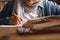 Asian muslim woman studying in library, exam preparation concept. Female college student doing research and making notes in her