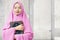 Asian Muslim woman in a veil standing and holding the Quran