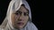 Asian muslim woman wearing hijab looking at camera with curious expression then shocked worried with big eyes open