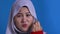 Asian muslim woman wearing hijab shows zip mouth gesture, keep secret don`t tell anyone