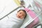 Asian newborn baby in  bassinet at delivery room at hospital