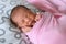 Asian newborn baby sleeping in pink cloth