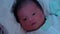 Asian newborn baby waking up open eyes looking around at night after parent sleep.Sleep cycle of newborn baby.Newborn baby life