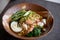 Asian noodle soup with meat, boiled egg, shrimp, spinach. Closeup with selective focus