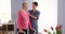 Asian nurse and elderly patient standing by window