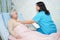 Asian nurse physiotherapist doctor care, help and support senior or elderly old lady woman patient