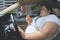 Asian obese woman using a phone in a car