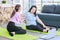 Asian old senior chubby pensioner retirement mother sitting on yoga mat having backache from stretching via online lesson when