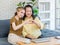 Asian old senior retirement pensioner chubby fat mother and young beautiful daughter sitting smiling together on sofa in living