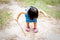 Asian one year old toddler is busy playing in a tropical park in the morning