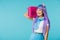 Asian otaku girl in purple wig holding boombox isolated on blue