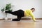 Asian overweight woman doing stretching exercise at home on fitness mat. Home activity training, online fitness class. Stretching