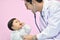 Asian paediatrician examining a baby with a stethoscope