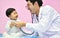 Asian paediatrician examining a baby with a stethoscope