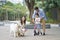 Asian parents & daughter playing scooter while walking dog in garden