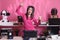 Asian performer holding cup of coffee while dancing in studio over pink background