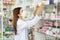 Asian pharmacist woman with protection mask in pharmacy store