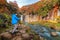 Asian photographer taking landscape photos of waterfall. Fall foliage in autumn season near Fujikawaguchiko, Yamanashi. Trees in