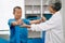 Asian physiotherapist helping elderly man patient stretching arm during exercise correct with dumbbell in hand during training