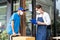 Asian Postman deliver food ingredient box to restaurant waiter in cafe. Attractive barista worker wear mask due to Covid-19, sign