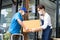 Asian Postman delivery in blue uniform send food ingredients box deliver to restaurant waiter in coffeehouse. Attractive barista