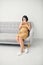 Asian pregnancy woman having a cough and cold fever sitting on sofa at home