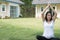 asian pregnant woman practicing yoga on green grass in front of