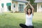 asian pregnant woman practicing yoga on green grass in front of