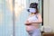 Asian Pregnant woman wearing virtual reality headset for Parenting trial. VR of pregnancy
