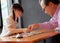 An Asian preschool girl learning to play board games with her grandfather