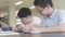 Asian preteens boys using tablet computer at library .