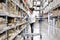 Asian pretty customer searching products in store warehouse. The girl using her hand point to the label to check the number at the