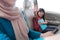 asian primary pupil student sitting in the car and waving good bye