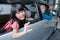 asian primary pupil student sitting in the car and waving good bye