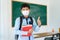 Asian primary student boy thumb up and  wearing masks to prevent the outbreak of Covid 19 in classroom while back to school reopen