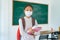 Asian primary students girl with backpack and books wearing masks to prevent the outbreak of Covid 19 in classroom while back to