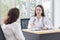 Asian professional doctor woman who wears medical coat talks with woman patient to suggest treatment guideline and healthcare