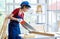 Asian professional female engineer architect foreman labor worker wears safety goggles hard helmet and jeans apron using handsaw