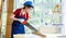 Asian professional female engineer architect foreman labor worker wears safety goggles hard helmet and jeans apron using handsaw