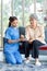Asian professional successful female internship nurse in blue uniform sitting on floor smiling using hand monitoring heart rate