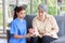 Asian professional successful female internship nurse in blue uniform sitting on floor smiling using hand monitoring heart rate