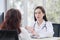 Asian professional woman doctor suggests healthcare solution to her patient elderly in examination room at hospital