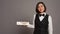 Asian receptionist pointing at wall indicator for conference room