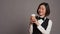 Asian receptionist serving coffee cup in front of camera