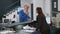 Asian receptionist talking to injured man with medical neck collar