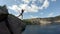 Asian red head young beautiful girls jump from a cliff into the lake. Slow motion GoPro shot