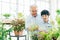 Asian retirement grandfather and his grandson spending quality time together insulated at home. Enjoy taking care of plants