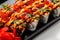 Asian rice and fresh fish rolls with hot sauce garnished with sliced onions and red fish roe. Stock image of exotic oriental food