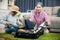 Asian romantic retired couple packing clothes travel bag suitcase together on floor at home