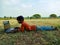 asian school kids learning about laptop computer system at natural green grass background in india January 2020